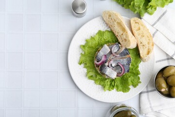 Delicious salad with herring and vegetables served on white tiled table, flat lay. Space for text