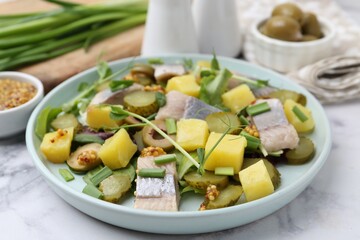 Delicious salad with herring and ingredients on white marble table, closeup