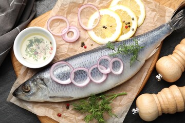 Tasty herring with spices on black table, flat lay