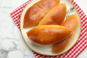Tasty baked patties on white marble table, top view