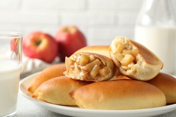 Tasty baked patties with apples and milk on table, closeup