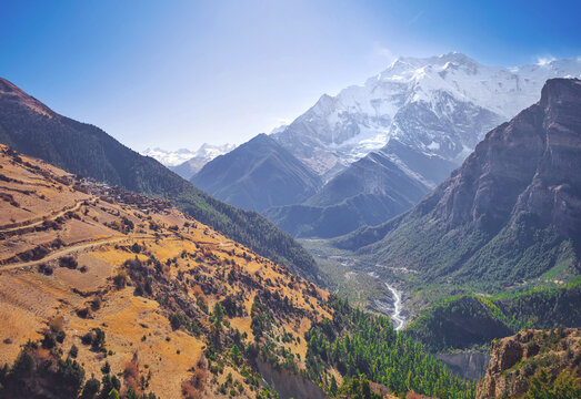 Himalayas, Nepal - The famous hiking on the roof of the world called Annapurna Circuit in the Himalaya range mountain, with little village, buddhist stupa and mountains of 8000 meters.