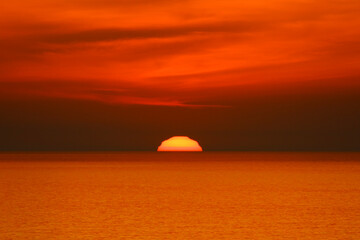 Fototapeta premium Orange red sunset. Footage of a clear sky and sunlight reflecting on the sea.