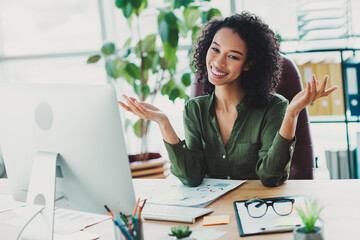 Confident young businesswoman in casual attire smiling at her office desk