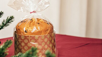 A delectable panettone elegantly wrapped in a clear cellophane bag, preserving its moist interior and festive charm while embodying Italian tradition.