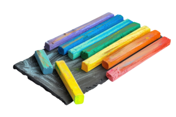 A vibrant collection of pastel chalks arranged artistically on a textured slate surface isolated on transparent background