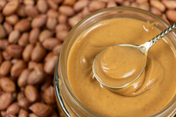 Peanut Butter in Spoon with Crunchy Peanut Background