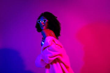 Stylish Woman Enjoys Vibrant Neon Light in Glamorous Setting With Fashion and Confidence