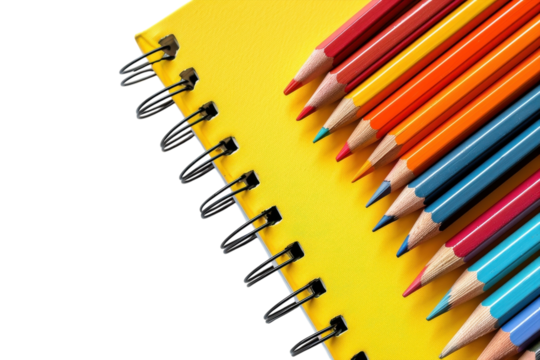 Colorful pencils arranged neatly beside a bright yellow notebook on a clean surface isolated on transparent background