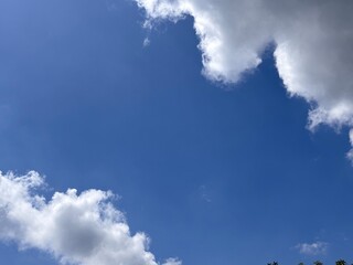 Beautiful blue sky with white clouds. The sky was clear and bright, and clouds were scattered all over the sky. The scene was peaceful and serene, as if the viewer was gazing at a beautiful day.