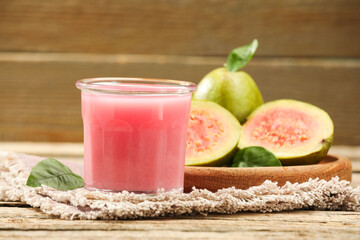 Refreshing guava juice and fresh fruits on wooden table, closeup