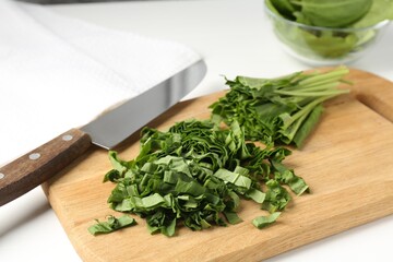 Cut fresh sorrel and knife on white table, closeup