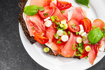 Bruschetta ham, tomato, greens dish fresh delicious gourmet food background on the table rustic food top view copy space