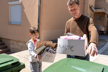 Father throws plastic waste into bin while child holds recyclables nearby
