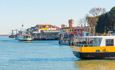 Ferry boats docking near colorful waterfront buildings on island