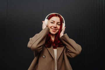 Portrait of a teenage girl smile and listen to music on wireless headphones