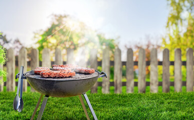 summer time in backyard garden with grill BBQ, wooden table, blurred background