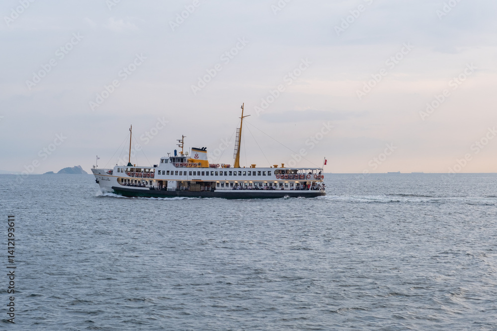 Aufkleber cruise boat sailing across the bosphorus at dusk with passengers enjoying the view of the istanbul s