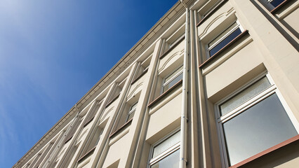 Concrete plastered building with windows, with afternoon sun. Modern building, urban architectural structure.