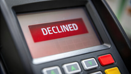 payment terminal displays declined message, indicating transaction failure due to insufficient funds or debt issues. This notice can be stressful
