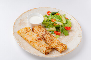 Savory crepes and a fresh salad of crisp greens and tomatoes make a perfect light meal