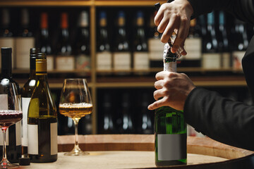 Person Opening Sparkling Wine in Wooden Cellar Close up