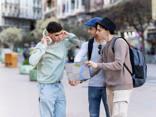 Young tourists looking at a map and asking for directions in the city center