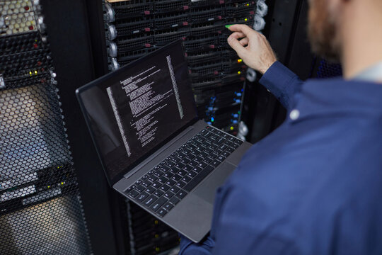 Technician resolving technical issues in a data center equipped with servers and monitoring laptop. Focused on troubleshooting and ensuring proper hardware functionality - Powered by Adobe