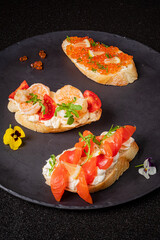 Three exquisite bites of tapas adorned with colorful toppings, perfect for a gourmet experience