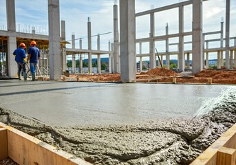 Fresh concrete being poured and leveled at a construction site