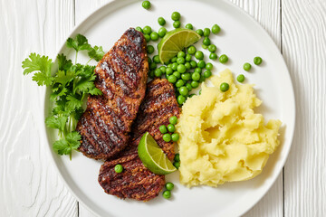 grilled beef cutlets with potato mash, green peas