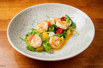 Fresh shrimp atop a bed of crisp spinach, accompanied by colorful citrus and gourmet toppings