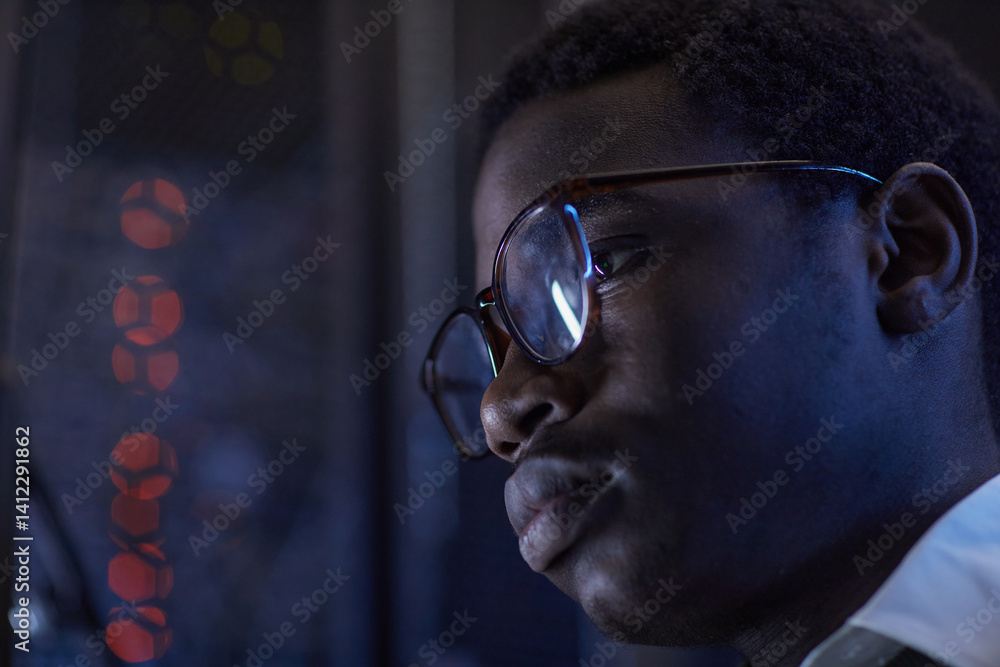 Poster detail of a person wearing glasses, engaged in data analysis with a backdrop of codes on monitors. t