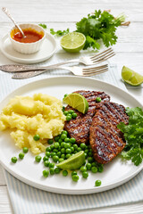 grilled beef cutlets with potato mash, green peas