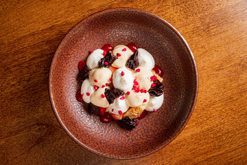 A delightful dessert with cream, fruits, and colorful toppings in a unique bowl