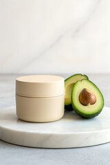 Minimalist Mockup Showcasing a Round Beige Cosmetic Jar Alongside Fresh Avocado Halves on a Marble Surface