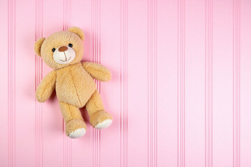 teddy bear sitting on top of a pink wooden surface