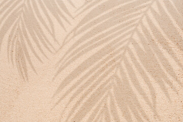 Obraz na płótnie Canvas Sand texture background,Summer beach with tropical coconut palm leaf shadow on brown sand background. Nature background of Minimal sunlight over lay on sand dunes for Summer holiday, vacation, travel