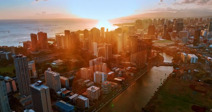 Light of sunset covering the scenery of Waikiki, Honolulu, Hawaii, USA. Approaching lively downtown flying over the Ala Wai Canal.