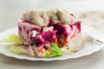 Delicious beetroot salad with herring on a served table