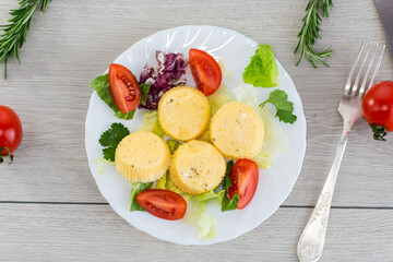 Round omelette with tomatoes and fresh lettuce on a served table