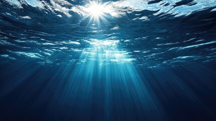 Dark blue ocean surface seen from underwater with sun rays shining through