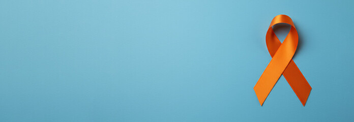 Skin cancer awareness month concept. Orange color ribbon on light blue background. Symbolic for Multiple Sclerosis day, self harm awareness, leukemia and kidney cancer. Poster, banner with copy space.