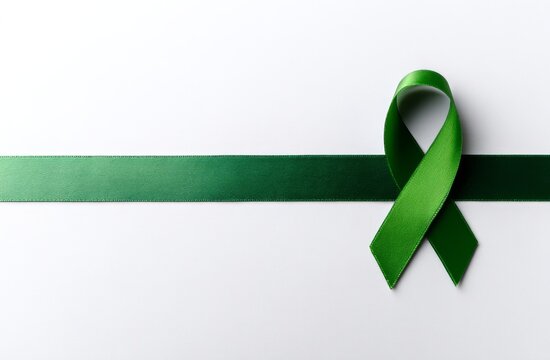 The symbolic green ribbon for cancer awareness is set against a white background, highlighting issues of organ donation and mental health - Powered by Adobe