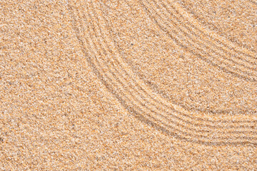 Japanese Zen Garden with concentric circles and parallel lines on brown sand surface...