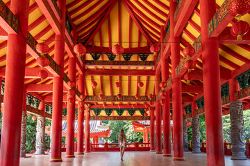 Tourist walking in sam poo kong temple semarang, indonesia with red pillars and lanterns