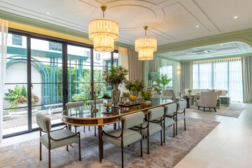 Beautiful luxurious traditional style dining room with bouquets of flowers on the table. Elegance dinning table with luxurious pendant.