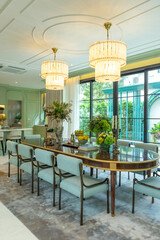 Beautiful luxurious traditional style dining room with bouquets of flowers on the table. Elegance dinning table with luxurious pendant.