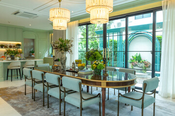 Beautiful luxurious traditional style dining room with bouquets of flowers on the table. Elegance dinning table with luxurious pendant.