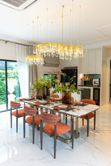 Beautiful luxurious traditional style modern dining room with bouquets of flowers on the table. Elegance dinning table with luxurious pendant.